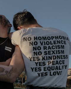 Two individuals showcasing an LGBTQ+ equality message in Istanbul for social change.